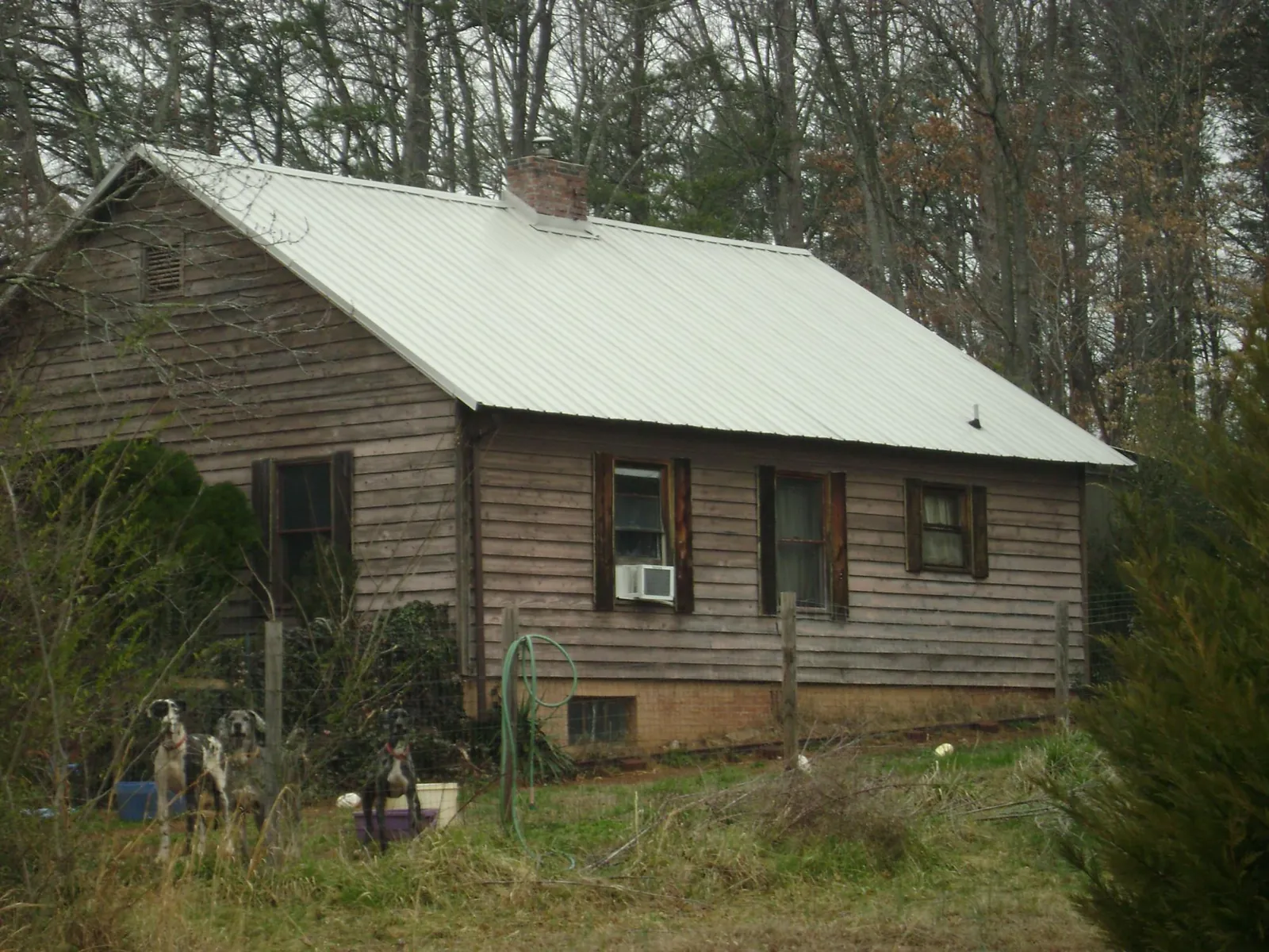 White metal roof on an old wood sided farmhouse, from a Metal Roof Installation job in Burns
